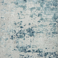 Blue and beige textured abstract modern rug with a distressed, multi-tonal pattern.