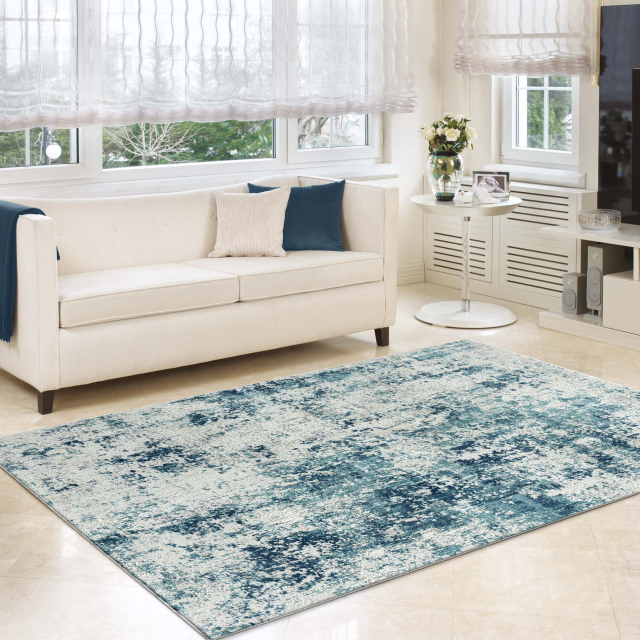 Blue and beige abstract patterned textured modern rug on light tile floor in bright living room.