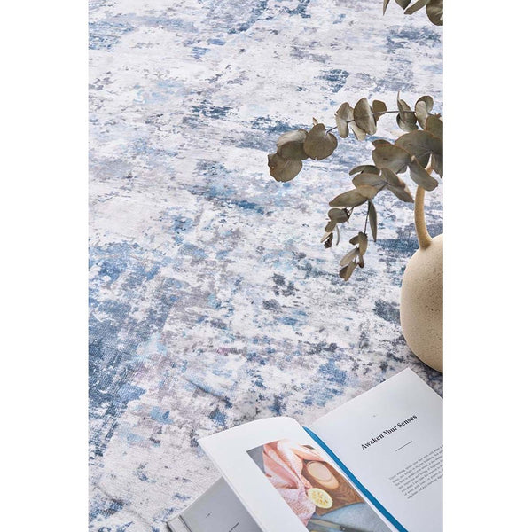 Blue and white abstract patterned modern rug with textured polyester weave.