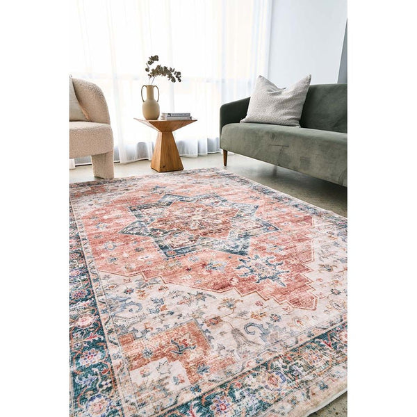 Rust and multi-colored patterned transitional rug with distressed vintage design on hardwood floor.