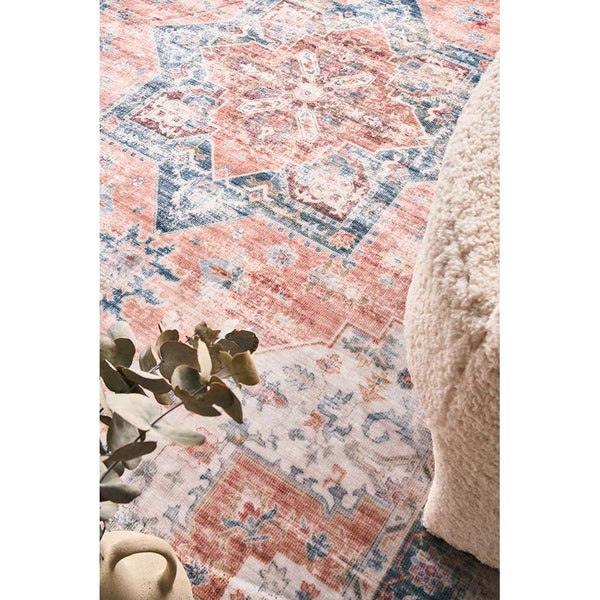 Rust, blue, and cream multi-colored transitional patterned rug with distressed vintage style edges.