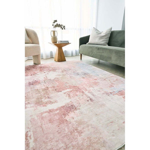 Pastel pink abstract patterned rug with soft texture in a modern living room setting.