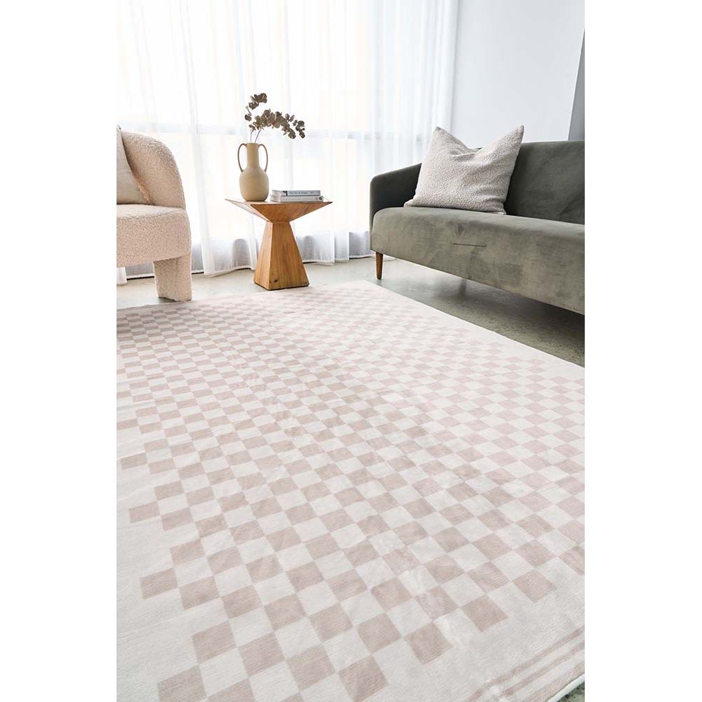 Natural beige and cream abstract checkered modern rug on wooden floor, paired with green sofa and beige chair.