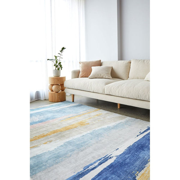 Modern abstract rug in blue, yellow, and beige tones with a soft, machine-washable polyester texture.
