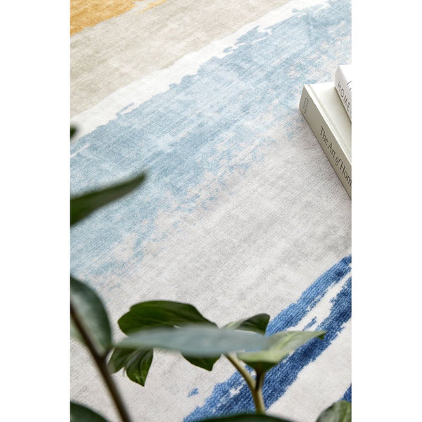 Abstract modern rug in soft blue, beige, and white tones with subtle brushstroke patterns.