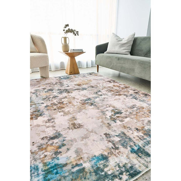 Multi-colored abstract modern rug with blue, beige, and brown tones in a living room setting.