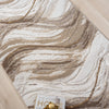 Beige and brown modern runner rug with abstract wavy pattern on light wood floor.