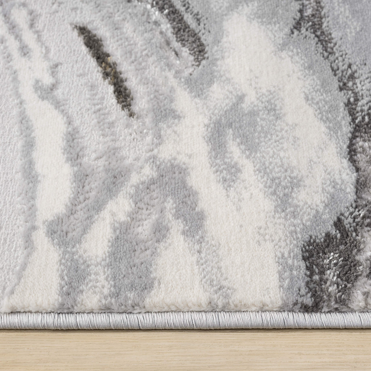 Grey and white abstract patterned modern runner rug with soft textured waves and a neatly finished edge.