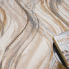 Beige modern rug with abstract wavy pattern in shades of brown, gray, and cream.