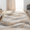 Beige modern rug with abstract wavy pattern in blue, gray, and gold tones on a light background.