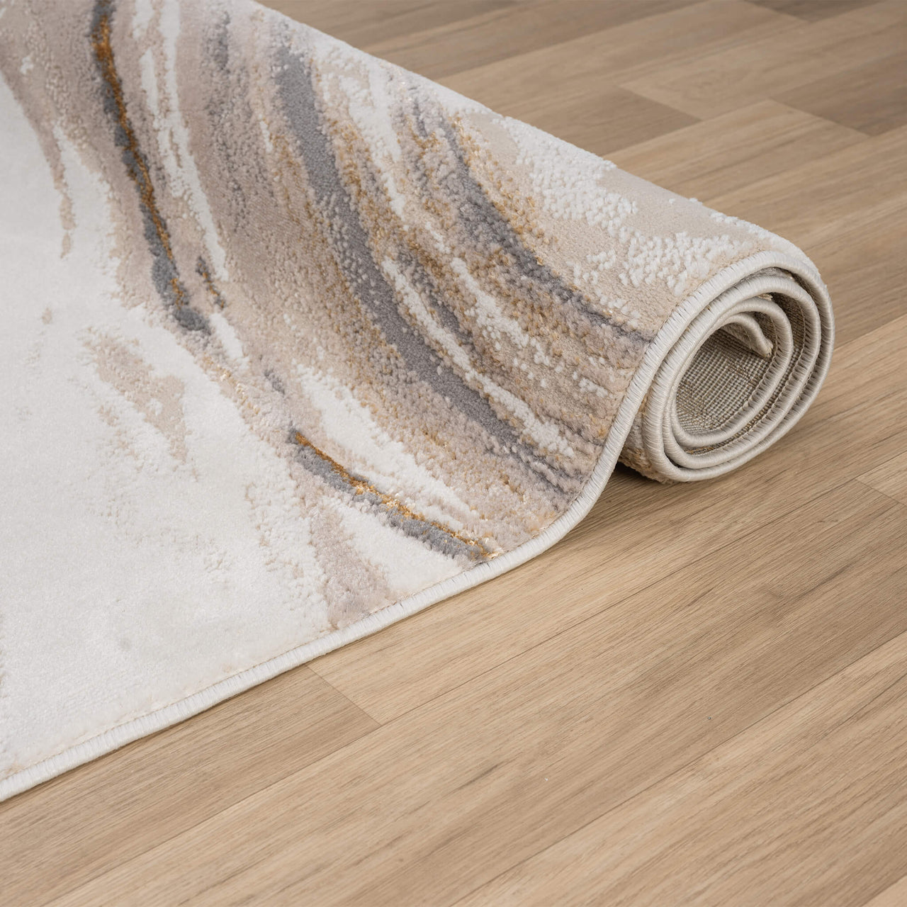Beige modern rug with wavy multi-color abstract pattern in cream, taupe, and gray tones on wood floor.
