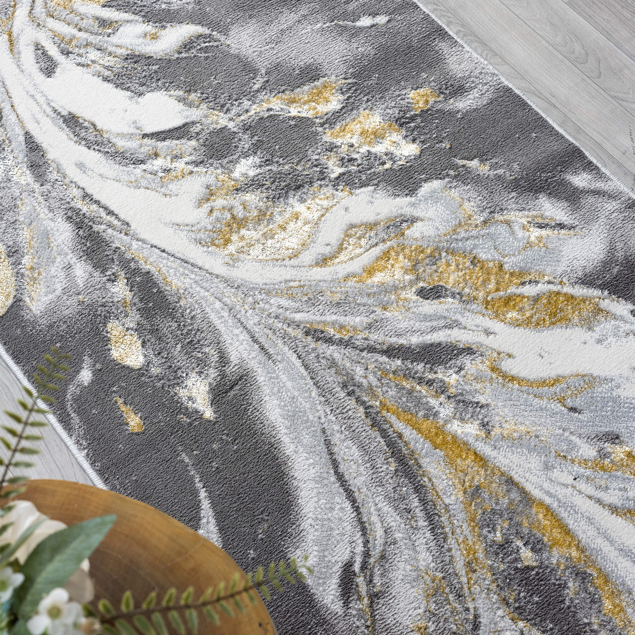 Grey runner rug with abstract swirling pattern in white and gold tones, polyester blend texture.
