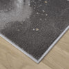 Close-up of grey runner rug corner with subtle multi-color abstract pattern and white stitched border on wood floor.