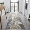 Grey runner rug with abstract swirling white and gold patterns on a modern hallway floor.