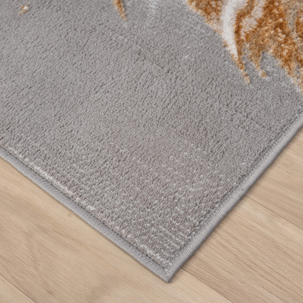 Close-up of a beige abstract runner rug corner with soft texture on light wood floor.