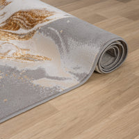 Beige and gray abstract patterned runner rug with gold accents on wooden floor.