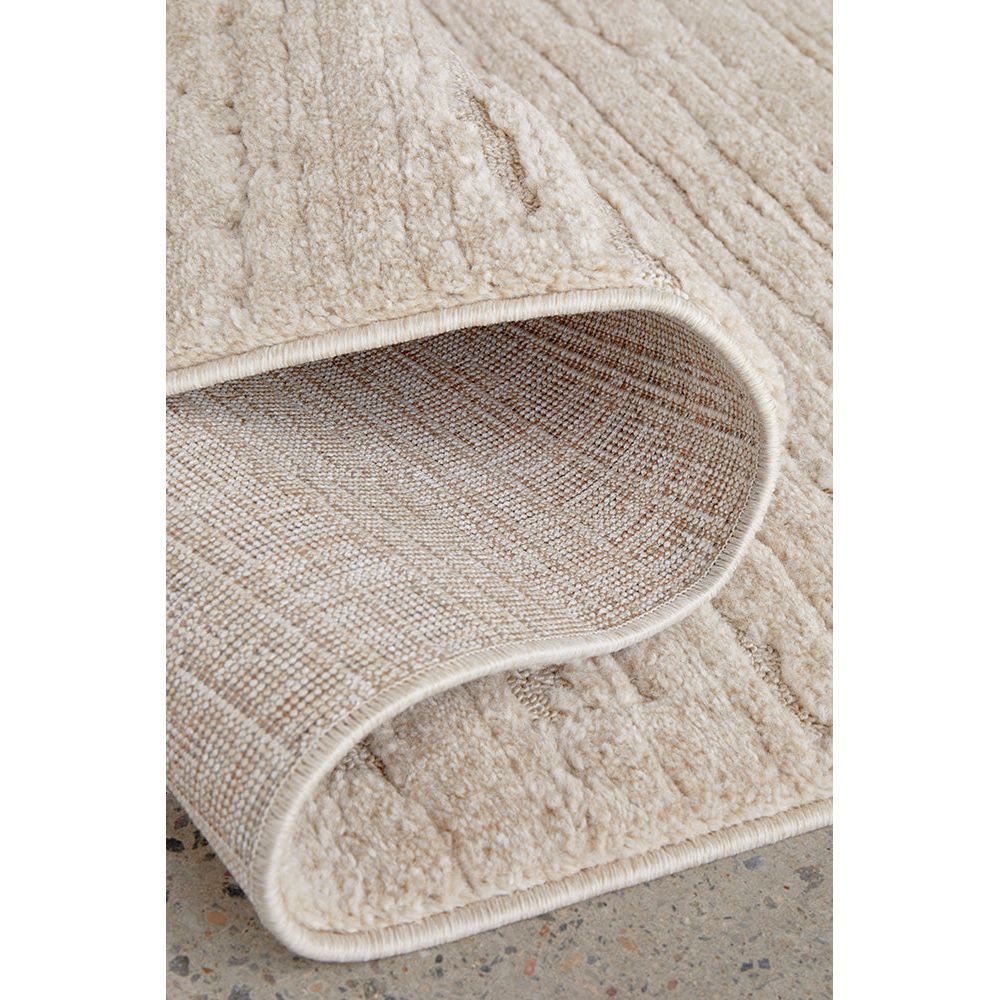 Close-up of a textured beige rug on a neutral background