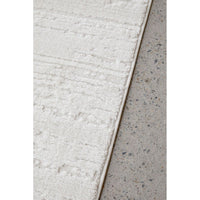 Close-up of a textured rug corner on a concrete floor