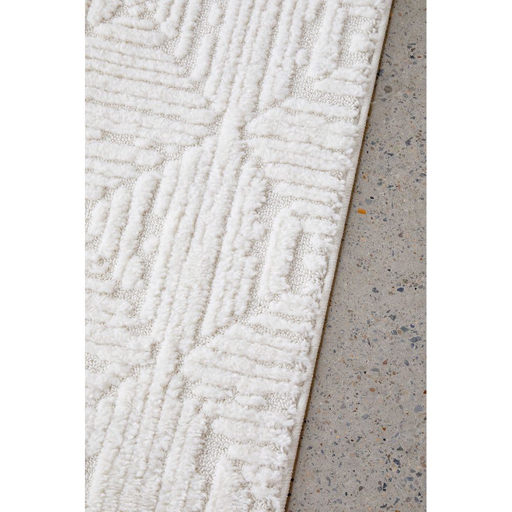 Textured white rug on a concrete floor