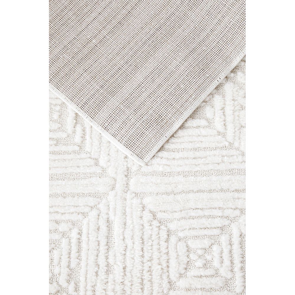 Close-up of textured beige and white rug with geometric pattern