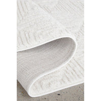 Close-up of a textured white rug on a concrete floor