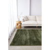 Green rug on a light grey floor with a white sofa and side table in the background.