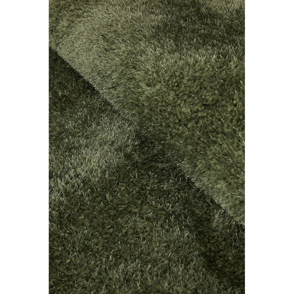 Soft shaggy rug in deep green with plush polyester pile texture.