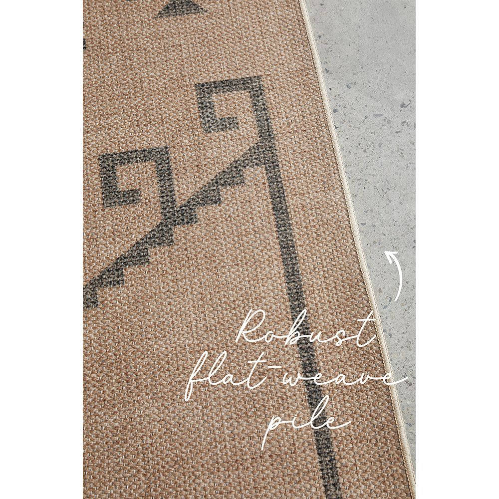 Textured rug with geometric pattern and robust flatweave pile on a neutral background