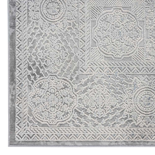 Grey rectangular rug with intricate raised geometric and floral patterns in a modern abstract design.