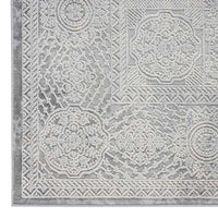Grey rectangular rug with intricate raised geometric and floral patterns in a modern abstract design.