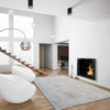 Grey abstract modern rug with subtle multi-coloured accents in sleek living room setting.