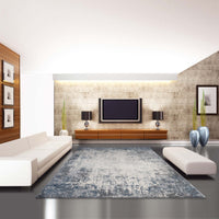 Grey multi-colored abstract modern rug with distressed texture in contemporary living room.