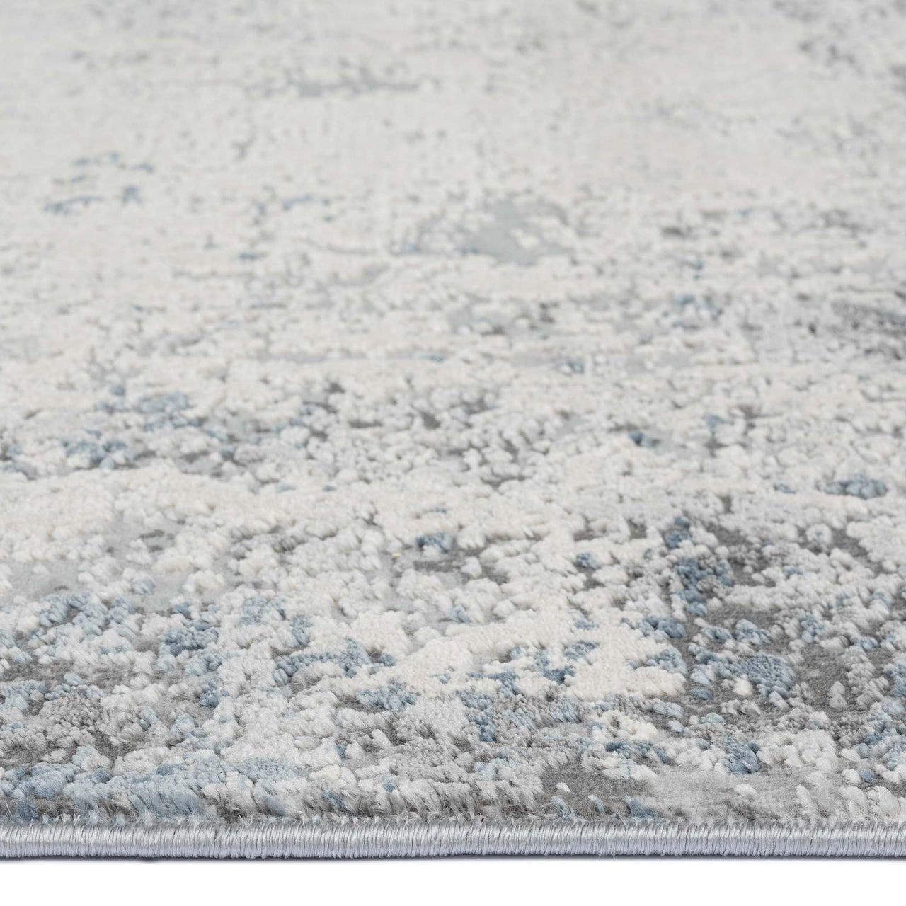 Grey runner rug with abstract multi-coloured pattern in soft blue and white tones, low-shedding texture.