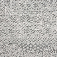 Grey runner rug with intricate raised abstract patterns and textured border detailing.