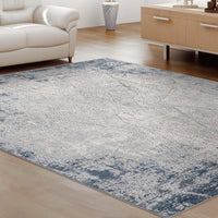 Blue grey abstract modern rug with textured pattern in living room setting.