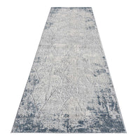 Blue grey abstract modern runner rug with textured multi-colored pattern and distressed edges.