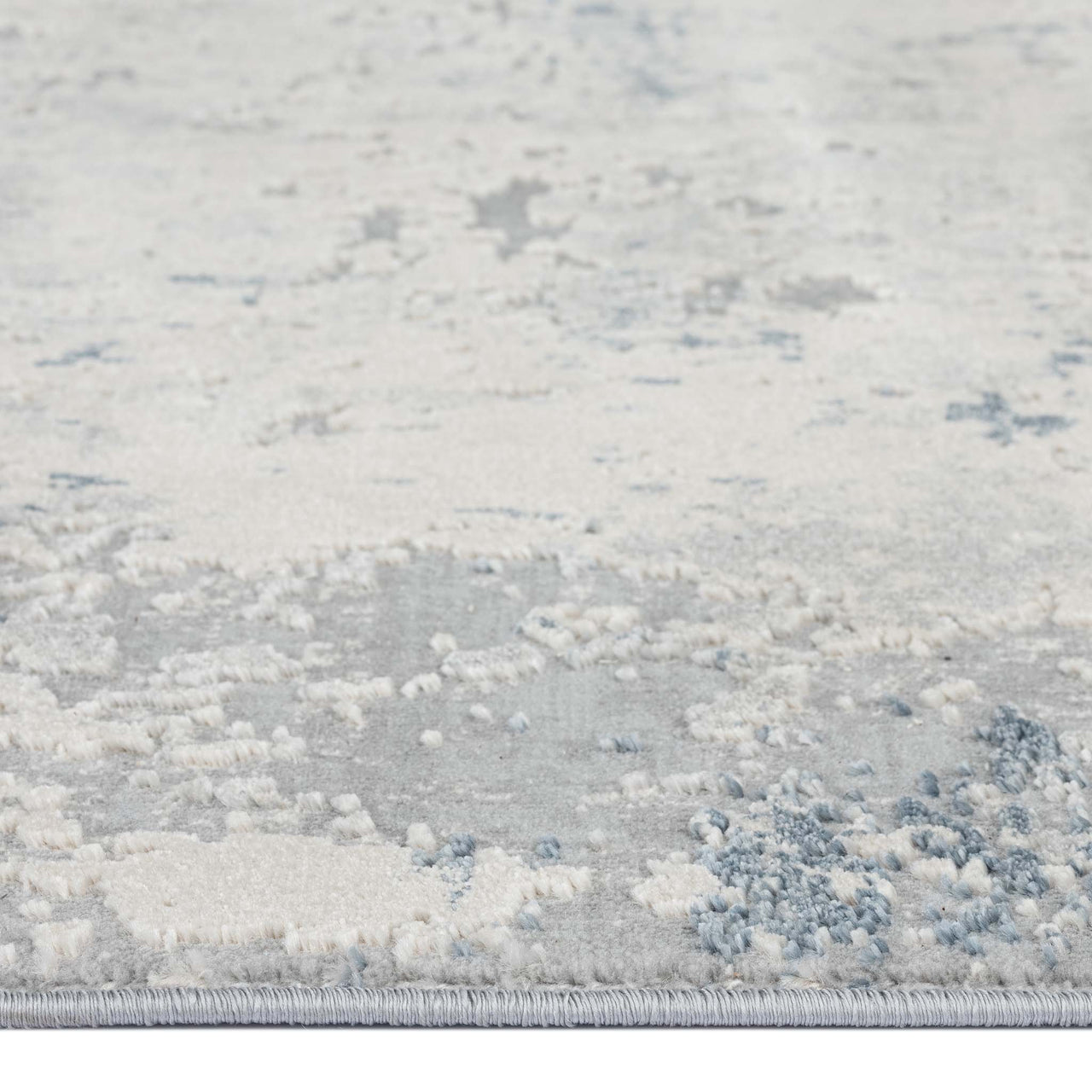 Grey abstract modern rug with subtle blue and white textured patterns, low pile surface.