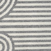 Close-up of grey flatweave rug with geometric arches and stripes pattern in monochrome tones.