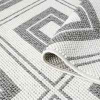 Grey flatweave rug with minimalist geometric square pattern and textured weave.