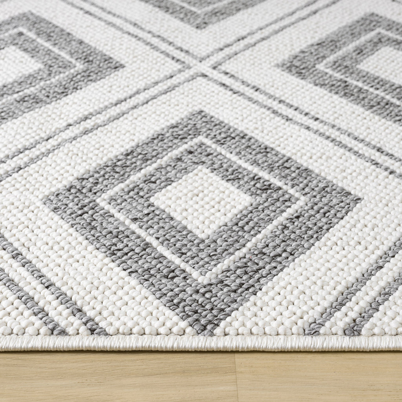 Grey and white flatweave runner rug with geometric square pattern and textured weave on hardwood floor.