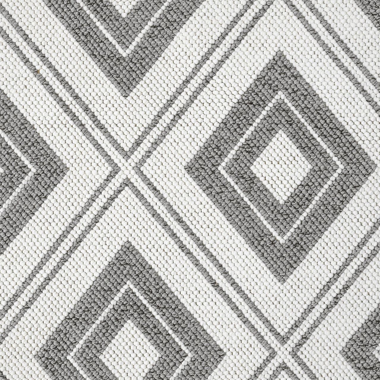 Grey flatweave rug with a modern geometric diamond pattern in monochrome tones.