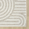 Cream flatweave rug with subtle concentric geometric pattern on light hardwood floor.