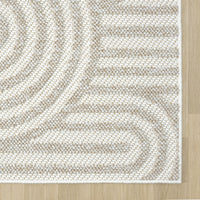 Cream flatweave rug with subtle concentric geometric pattern on light hardwood floor.