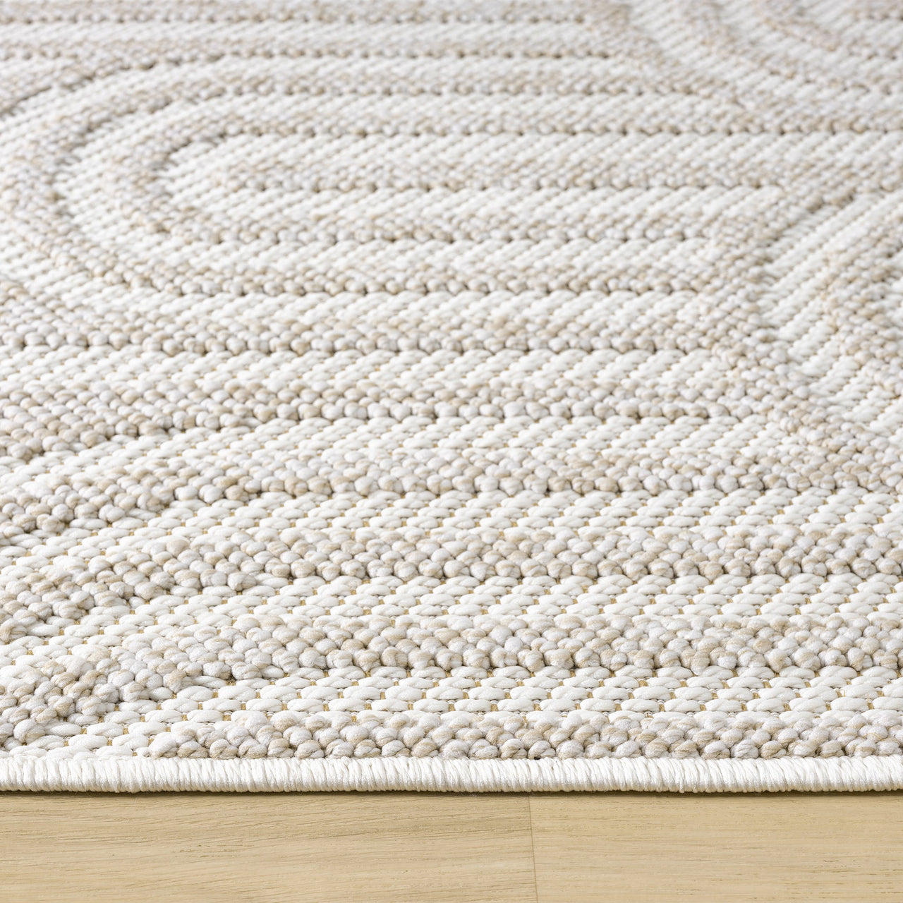 Cream flatweave runner rug with textured geometric patterns on wooden floor.