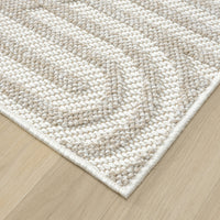 Cream flatweave rug with textured geometric arch pattern and subtle beige accents.