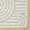 Cream flatweave rug with textured arches and geometric patterns on a light floor.