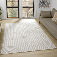Cream flatweave rug with geometric arches pattern in beige tones on light hardwood floor.