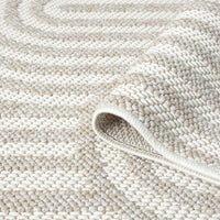 Cream flatweave rug with textured arches pattern in a minimalist modern design.
