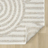 Cream flatweave rug with geometric arch and stripe pattern in beige tones on wood floor.
