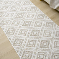 Cream flatweave runner rug with beige geometric diamond pattern on light wood floor.
